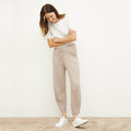 Front image of a woman standing wearing the Addison Jogger—Cashmere/Wool in Oatmeal Melange | Lead