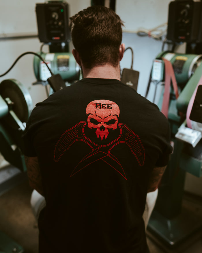 Man wearing black Bee skull graphic T-shirt in workshop with industrial machines