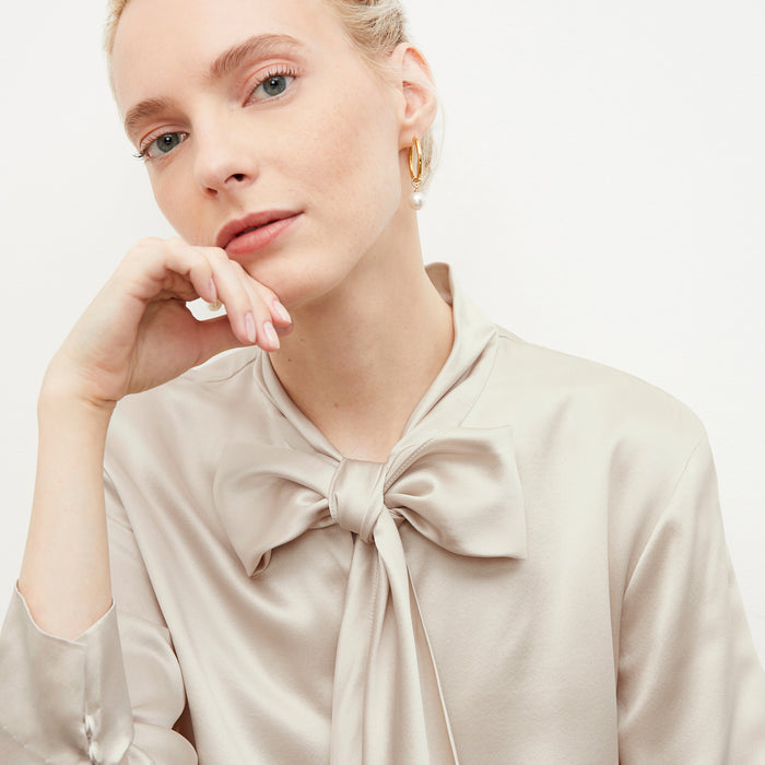 woman wearing the claude charms in gold
