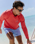 The lifestyle view of the Southern Tide Crossed Lines Coastal Breeze® Performance Hoodie by Southern Tide - Channel Marker Red