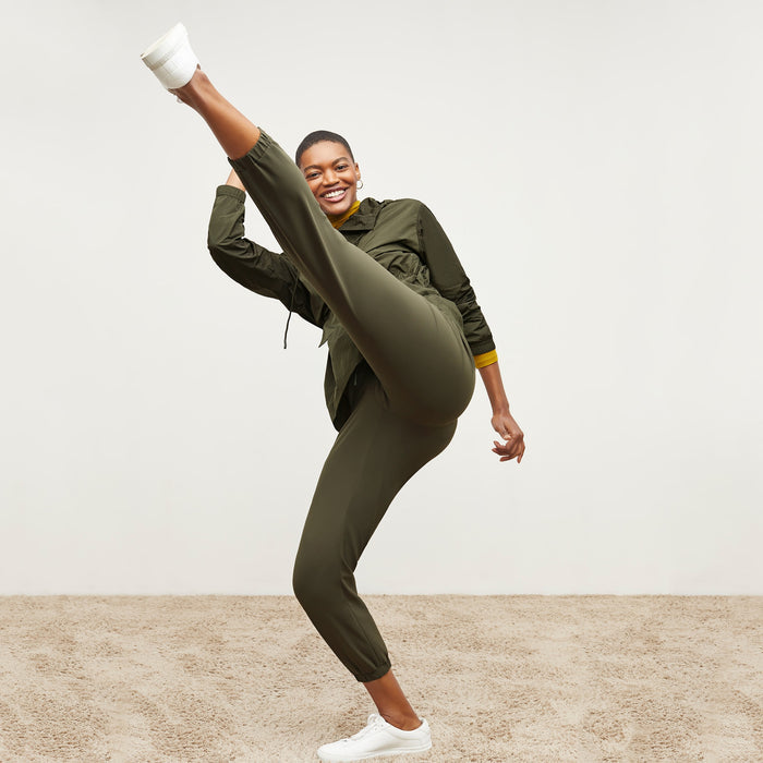 Back image of a woman standing wearing the Delaney Jogger—OrigamiTech in Olive