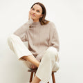 Front image of a woman standing wearing the Freya Hoodie—Cashmere/Wool in Oatmeal Melange | Lead