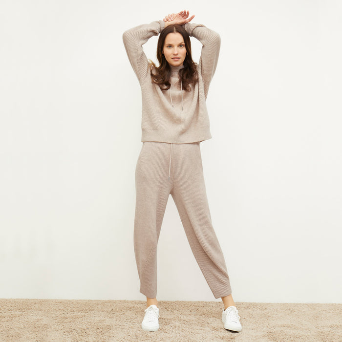 Front image of a woman standing wearing the Freya Hoodie—Cashmere/Wool in Oatmeal Melange