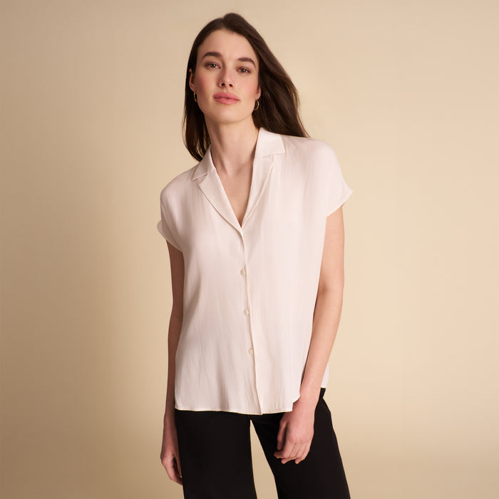 woman in white blouse on beige background. | Lead