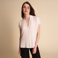 woman in white blouse on beige background. | Lead