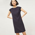 Front image of a woman standing wearing the Maaza Dress—Origami Suiting in Cool Charcoal | Lead