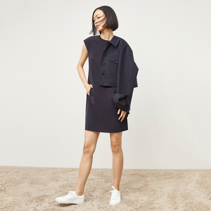 Front image of a woman standing wearing the Maaza Dress—Origami Suiting in Cool Charcoal
