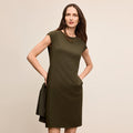 Woman wearing a green dress against a beige background | Lead