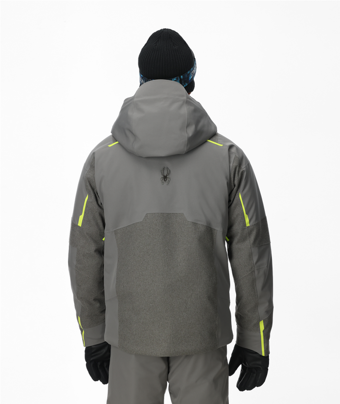 Person wearing a gray jacket with yellow accents on a white background