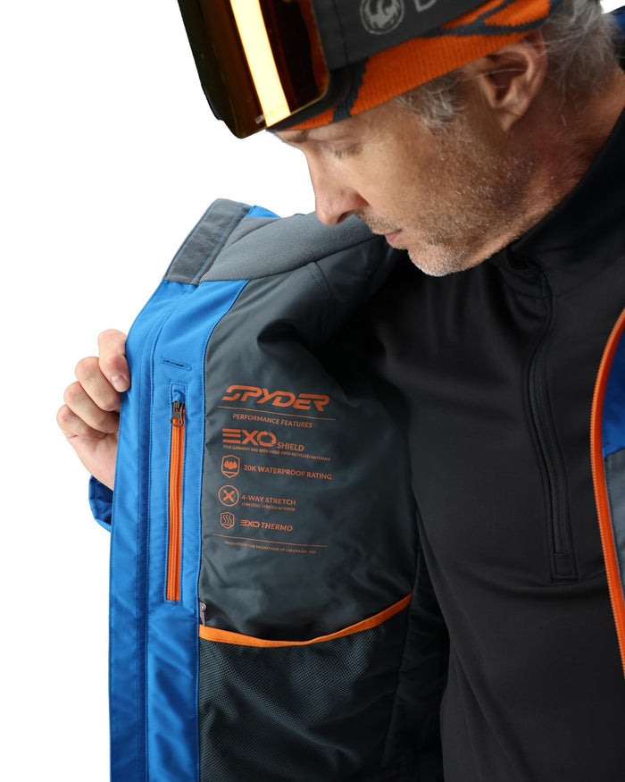 Person wearing a Spyder jacket with a helmet on a white background