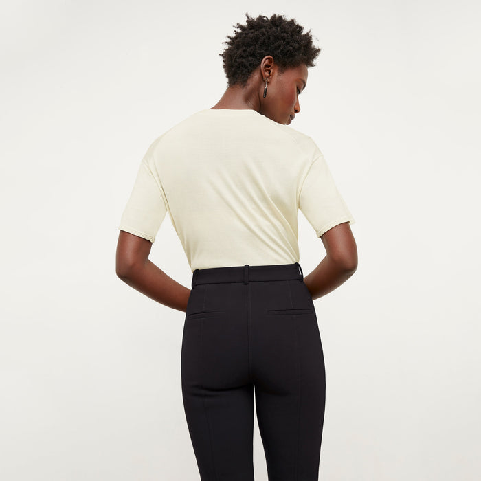 Back image of a woman standing wearing the mia top in silk jersey in cream