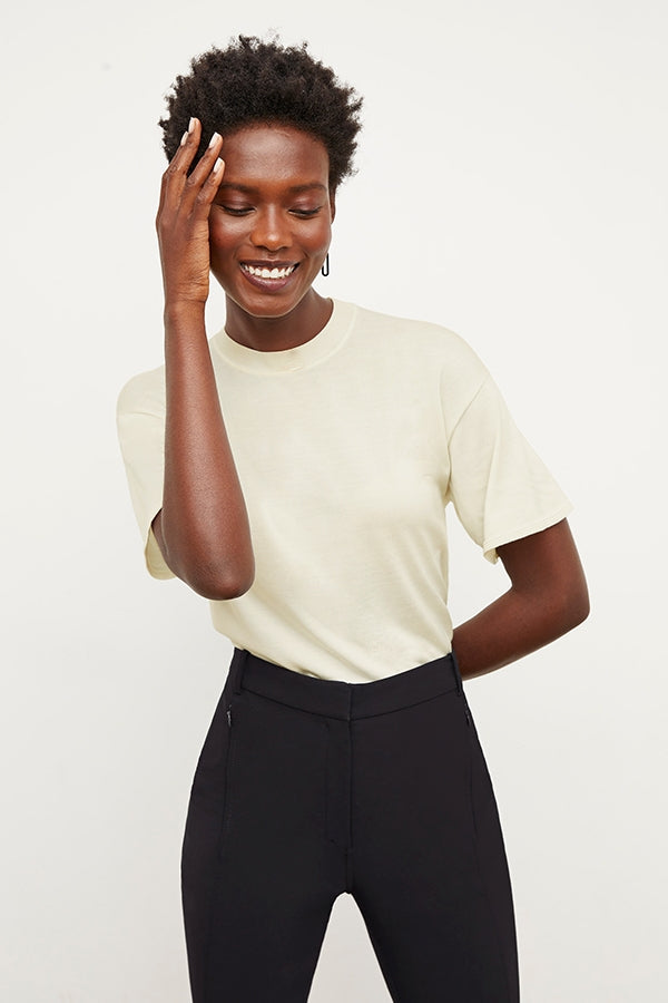 Front image of a woman standing wearing the mia top in silk jersey in cream | Grid | Exclude