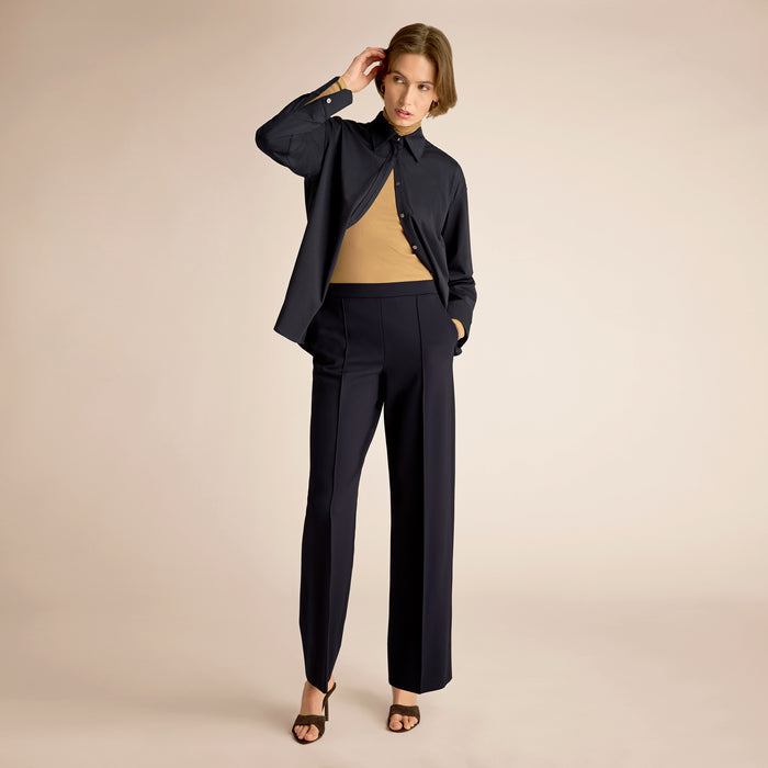 Navy blue pants worn by a person on a beige background