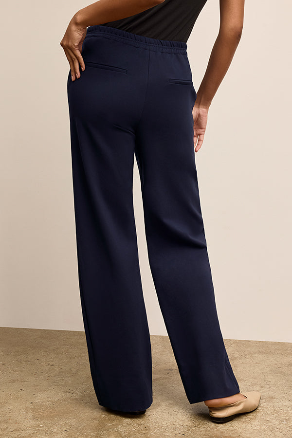 Navy blue wide-leg pants worn by a person on a beige background | Exclude