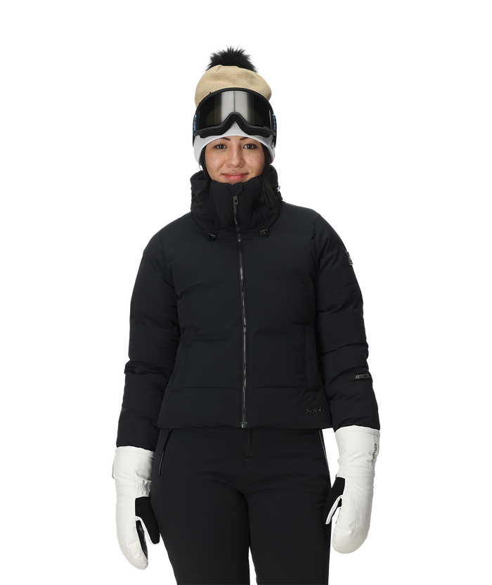 Person wearing a black puffer jacket, white gloves, and a beanie with goggles on a white background